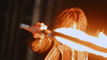a person in a leather jacket is holding a torch in front of their face with flames coming out of it