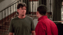 a man in a red shirt and a man in a green shirt are standing next to each other