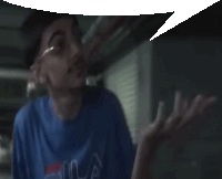 a man wearing a blue fila shirt with a speech bubble above his head