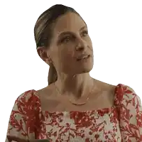 a woman in a red and white floral dress looks to the side