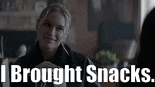 a woman sitting at a table with the words i brought snacks