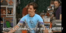 a man in a blue tie dye shirt is standing in a store talking to someone .