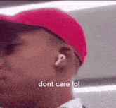 a man wearing ear buds and a pink hat says dont care lol
