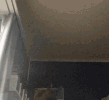 a person standing in a room with a gray curtain