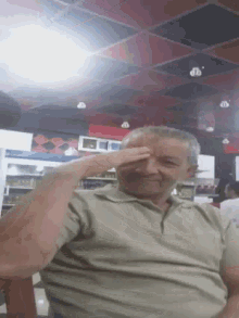 a man covering his eyes with his hand in front of a pepsi fridge