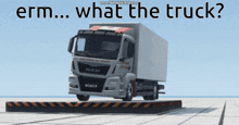 a man truck is sitting on a platform with the words erm what the truck