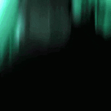 a blurry picture of a person 's face with a green background .