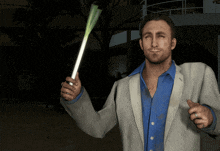 a man in a suit and blue shirt holds a green stick