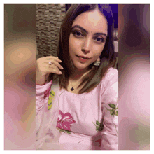 a woman in a pink floral dress is taking a picture of herself