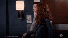 a man and a woman are standing next to each other in an elevator talking on a cell phone .