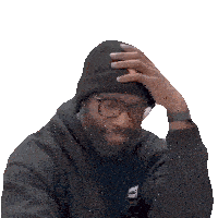 a man wearing a beanie and glasses holds his hand to his forehead