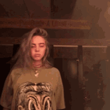 billie eilish is wearing a sweater with a lion on it .