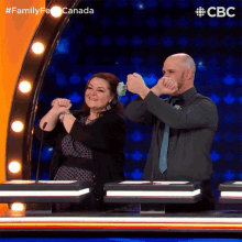 a man and a woman are playing a game called family feud