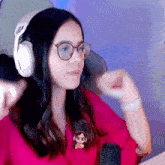 a woman wearing glasses and headphones is sitting in front of a microphone .