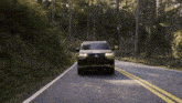 a car driving down a road with trees on the side