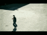 a person walking on a concrete surface with a shadow on it