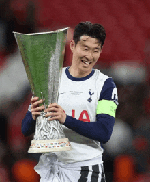 a soccer player holds a trophy that says final milan 2020