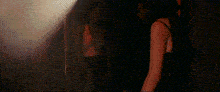 a man and a woman are standing next to each other in a dark room in a dark room .