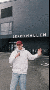 a man is standing in front of a building that says leroyhallen