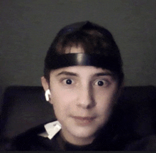 a man wearing a headband and ear buds looks at the camera