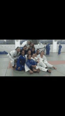 a group of women are posing for a picture while wearing karate uniforms