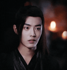 a close up of a young man 's face with a dark background