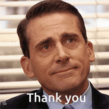 a man in a suit and tie is making a sad face and saying thank you .