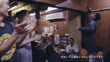 a man in a guns n roses shirt holds up a bottle of beer