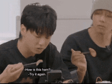 two young men are eating ham and one of them is asking how is this ham try it again