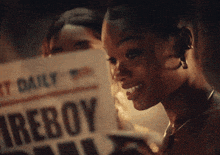 a woman is reading a newspaper with the headline fireboy