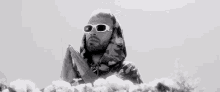 a black and white photo of a man wearing sunglasses and a camouflage jacket