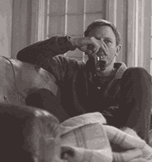 a man sits on a couch drinking a glass of wine