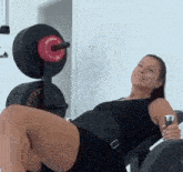 a woman is sitting on a machine in a gym with a bottle of water .