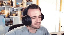 a man wearing headphones is sitting in a chair in front of a computer .