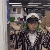 a person wearing a striped jacket and hat with the letter b on it