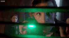 a green light is shining on a person 's face in a dark room