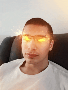 a man wearing glasses and a white shirt looks at the camera