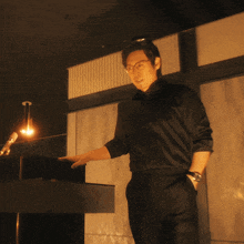 a man in a black shirt stands in front of a podium