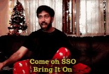 a man is sitting on a couch with the words come on sso bring it on