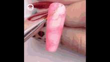 a close up of a person 's nails being painted with a nail polish brush .