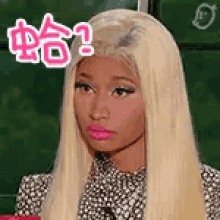 a woman with blonde hair and pink lips is wearing a polka dot dress and making a funny face .
