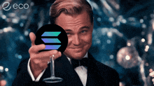 a man in a tuxedo is holding a coin and a glass of wine in front of an eco logo