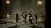 a group of women are dancing in a room with a patterned floor