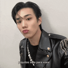 a young man wearing a black leather jacket with the words piquitos solo para xiare written below him