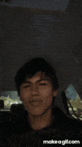 a young man is sitting in the back seat of a car and making a funny face