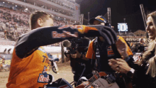 a man wearing a red bull shirt shakes hands with someone