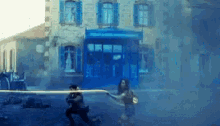 a man and a woman are walking down a street in front of a building with blue shutters .