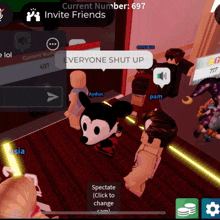 a group of people are playing a video game and one of them has a mickey mouse head on his head