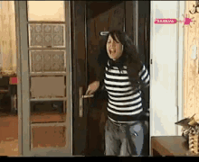 a woman is standing in front of a door with a sign that says zabava