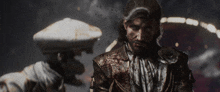 a man with blood on his face is standing next to another man in a hat